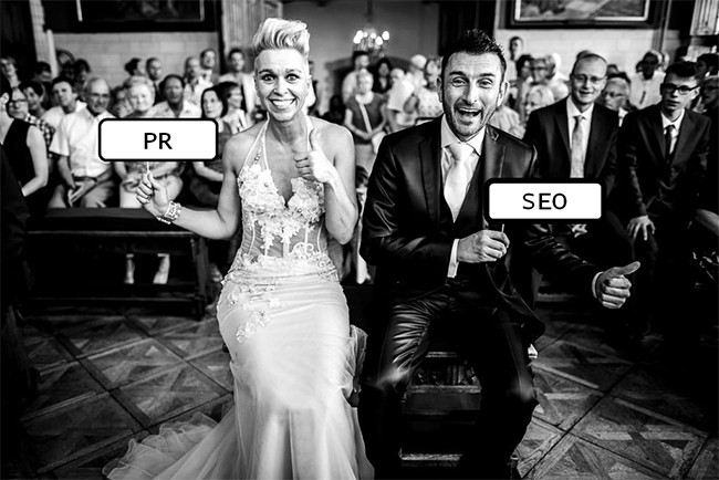 Bride holding sign that says "PR," groom holding sign that says "SEO"